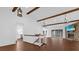 Bright living room featuring wood beams, stone fireplace, staircase, and sliding glass doors to the patio at 128 W Juliana Way, Auburndale, FL 33823