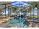Stunning screened pool area featuring a waterfall, spa, lush landscaping and lake views at 128 W Juliana Way, Auburndale, FL 33823