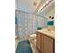 Cozy bathroom showcasing a vanity, toilet, and shower with decorative curtain, enhanced by bright lighting at 2555 Oneida Loop, Kissimmee, FL 34747