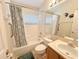 Bright bathroom features a tiled tub/shower combination, vanity, toilet, and grab bar for accessibility at 2555 Oneida Loop, Kissimmee, FL 34747