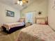 Charming bedroom featuring twin beds with floral quilts, complemented by a ceiling fan and natural light at 2555 Oneida Loop, Kissimmee, FL 34747