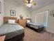 Cozy bedroom with twin beds, carpet flooring, and a ceiling fan, providing a comfortable and relaxing space at 2555 Oneida Loop, Kissimmee, FL 34747