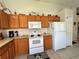 Functional kitchen showcasing ample cabinetry, white appliances, and tile flooring, ideal for everyday cooking at 2555 Oneida Loop, Kissimmee, FL 34747