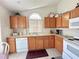 Well-lit kitchen featuring light wood cabinets, white appliances, and a bright window for a cheerful cooking experience at 2555 Oneida Loop, Kissimmee, FL 34747
