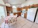 Bright kitchen features tile flooring, white appliances, and a quaint breakfast nook with table set for four at 2555 Oneida Loop, Kissimmee, FL 34747