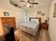 Comfortable bedroom with a queen-sized bed and ceiling fan, with a view into the hall at 2555 Oneida Loop, Kissimmee, FL 34747