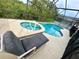 Pool with jacuzzi with chair seating and a screened enclosure at 2555 Oneida Loop, Kissimmee, FL 34747