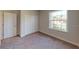 Well-lit bedroom with neutral walls, carpet flooring, and a double-door closet at 2229 Elegant Manor Cir, Edgewater, FL 32141