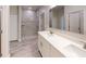 Double vanity bathroom with quartz countertops, a shower, and wood-look tile floor at 2235 Elegant Manor Cir, Edgewater, FL 32141