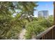 Balcony view with a metal railing, lush trees, and an overlook of the parking area at 911 N Orange Ave # 408, Orlando, FL 32801