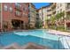 Outdoor swimming pool with chairs on a brick deck and multiple buildings at 911 N Orange Ave # 408, Orlando, FL 32801