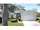 Light blue house with two-car garage and landscaped yard at 3507 Tenby Cir, Clermont, FL 34711