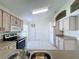 Kitchen features light wood cabinets, tile flooring, and stainless steel appliances at 3507 Tenby Cir, Clermont, FL 34711