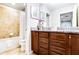 Bathroom featuring a shower with tile surround, dual vanity and wooden cabinetry at 2054 Rome Dr, Kissimmee, FL 34747