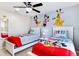 Cheerful bedroom with twin beds, ceiling fan and colorful cartoon character wall art at 2054 Rome Dr, Kissimmee, FL 34747