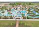 Resort-style pool with lazy river, water slides, umbrellas, lounge chairs, and palm trees at 2054 Rome Dr, Kissimmee, FL 34747