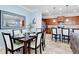 Dining room view with black chairs and white cushions set for dinner in an open space with the kitchen at 2054 Rome Dr, Kissimmee, FL 34747