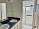 Bright bathroom featuring a double sink vanity and a tiled glass-enclosed shower at 5450 Watervista Dr, Orlando, FL 32821