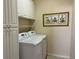 Laundry room equipped with a modern washer and dryer, complemented by overhead storage at 5450 Watervista Dr, Orlando, FL 32821