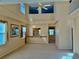 Bright living room with high ceilings, neutral carpet, large windows, and a decorative chandelier at 5450 Watervista Dr, Orlando, FL 32821