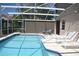 Screened pool features a table and chairs and several lounge chairs for relaxing by the water at 5450 Watervista Dr, Orlando, FL 32821