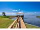 Picturesque waterfront view of a private dock with a covered gazebo on a sunny day at 2205 Cypress Cove Dr, Tavares, FL 32778