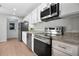 Modern kitchen featuring stainless steel appliances, granite countertops, and white cabinetry at 2205 Cypress Cove Dr, Tavares, FL 32778