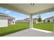 A covered patio overlooks a large green backyard with a white fence in a residential neighborhood at 4054 Serene Water Ave, Eustis, FL 32736