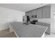 Open concept kitchen with gray cabinets, stainless steel appliances, granite countertops and tiled flooring at 4054 Serene Water Ave, Eustis, FL 32736