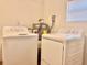Tile laundry area featuring modern washer and dryer, with convenient access to the water heater at 544 S Cottage Hill Rd, Orlando, FL 32805