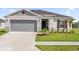 Charming single-story home featuring a gray stucco facade, neat landscaping, and a spacious driveway leading to an attached garage at 2633 Hancock Crossing Dr, Bartow, FL 33830