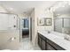 Double vanity bathroom with a large mirror and shower at 8831 Interlocking Ct, Davenport, FL 33896