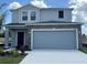 Two-story home with a stone accent garage, well-manicured landscaping, and a concrete driveway at 5583 Maddie Dr, Haines City, FL 33845