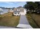 Two-story house with light beige and brown siding, paver driveway at 124 Lake Dr, Oviedo, FL 32765