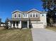 Two-story house with light brown and beige siding, light blue door, and a paved driveway at 124 Lake Dr, Oviedo, FL 32765