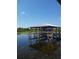 A community boat dock with an open roof and boat lift with a water view at 4904 W Fountainwood Dr, St Cloud, FL 34772