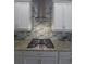 Modern kitchen with white cabinets, stainless hood, granite counters, and blue tile backsplash at 4904 W Fountainwood Dr, St Cloud, FL 34772