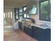 Covered outdoor kitchen boasts stainless steel grill, sink, and dark cabinets with granite counters at 4904 W Fountainwood Dr, St Cloud, FL 34772