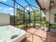 Relaxing screened patio featuring a modern hot tub, brick flooring, and view to the backyard at 4904 W Fountainwood Dr, St Cloud, FL 34772