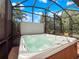 Beautiful view of a hot tub with green plants and a screened-in lanai at 4904 W Fountainwood Dr, St Cloud, FL 34772