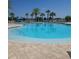 A large community swimming pool is surrounded by lounge chairs and mature palm trees overlooking the water at 4904 W Fountainwood Dr, St Cloud, FL 34772