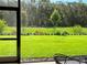 Manicured backyard and lush lawn offer a serene view of the outdoors from the covered patio at 3962 Kennebunk Loop, Mount Dora, FL 32757