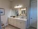 Elegant bathroom featuring a large mirror, white cabinetry, and a stylish countertop with sink at 3962 Kennebunk Loop, Mount Dora, FL 32757