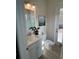 Small bathroom with white vanity, stylish fixtures, and a decorative painting above the toilet at 3962 Kennebunk Loop, Mount Dora, FL 32757