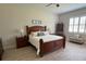 Comfortable bedroom with a wooden bed frame, ceiling fan, and bright windows at 3962 Kennebunk Loop, Mount Dora, FL 32757