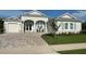 Charming single-story home featuring a light gray exterior, a paved driveway and light blue shutters at 3962 Kennebunk Loop, Mount Dora, FL 32757