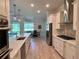 Modern kitchen featuring stainless steel appliances, sleek countertops, and an open design overlooking the dining area at 3962 Kennebunk Loop, Mount Dora, FL 32757