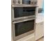 Modern stainless steel double ovens compliment the white cabinetry in this kitchen with a modern cooktop at 3962 Kennebunk Loop, Mount Dora, FL 32757