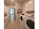 Well-organized laundry room featuring a washer, dryer, and ample white cabinetry for storage at 3962 Kennebunk Loop, Mount Dora, FL 32757