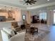 Spacious living room with wood-look tile flooring, modern lighting, and an open layout to the kitchen at 3962 Kennebunk Loop, Mount Dora, FL 32757